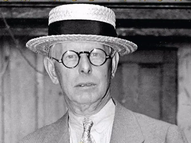 Jesse Livermore wearing a straw boater hat and round spectacles